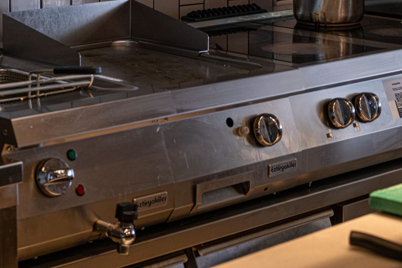 Cozinha industrial equipada com panelas e utensílios em aço inoxidável
