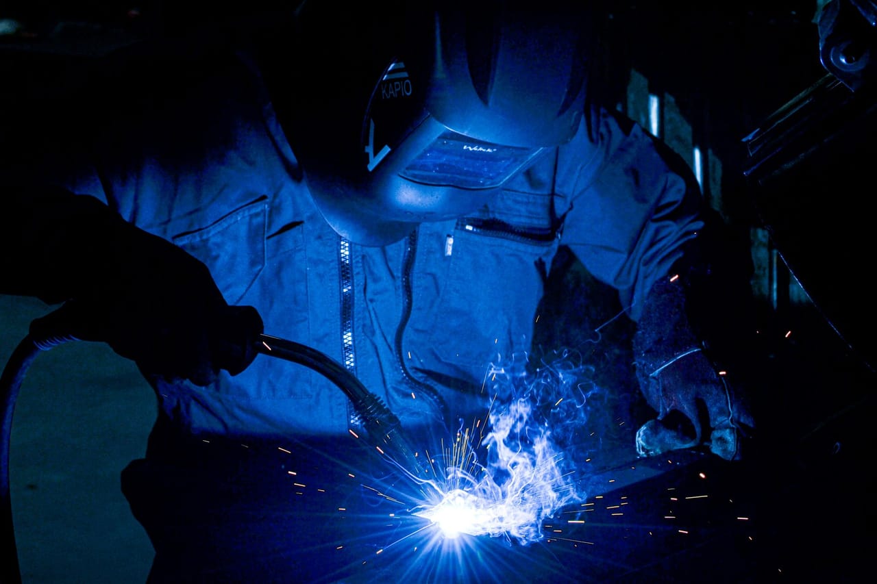 Profissional executando soldagem em estrutura metálica industrial